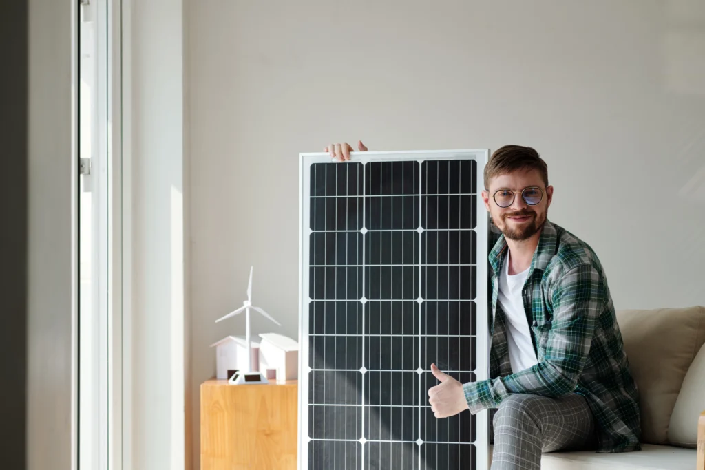 Homme-joyeux-avec-panneau-solaire Les avantages des panneaux solaires